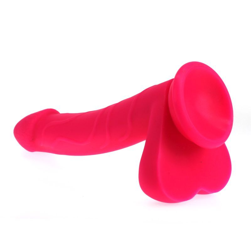 Penis shaped dildo with balls on a suction base in pink colour.